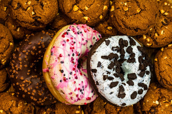 巧克力芯片<strong>饼干饼干</strong>和色彩斑斓的甜甜圈前视图和背景上釉甜甜圈和<strong>饼干</strong>