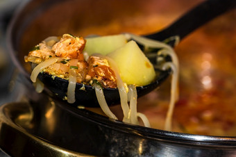 准备汤与鸡和蔬菜关闭沸腾汤焦点勺子与面条和蔬菜