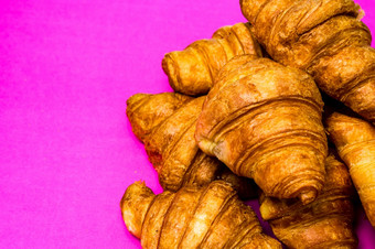 法国早餐概念关闭美味的新鲜的羊角面包孤立的粉红色的董事会法国早餐概念关闭美味的新鲜的羊角面包孤立的粉红色的董事会