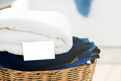 关闭空业务卡衣服和白色织物篮子与洗机背景洗衣概念
