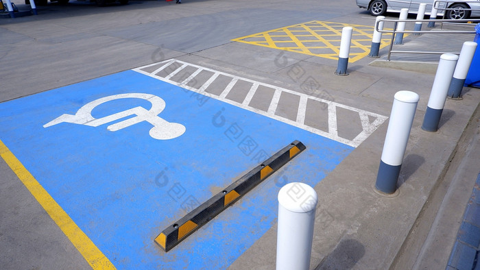 禁用轮椅和停车标志与轮塞和金属波兰混凝土地面停车区域气体和汽油站