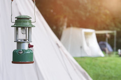 焦点野营乙炔灯笼与模糊背景白色帐篷野营区域的森林