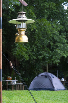 焦点古董野营黄铜灯笼与模糊背景帐篷绿色草坪上野营区域自然公园垂直框架