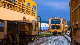的角度来看视图的老橙色柴油机车停车铁路火车车库对蓝色的天空自然背景