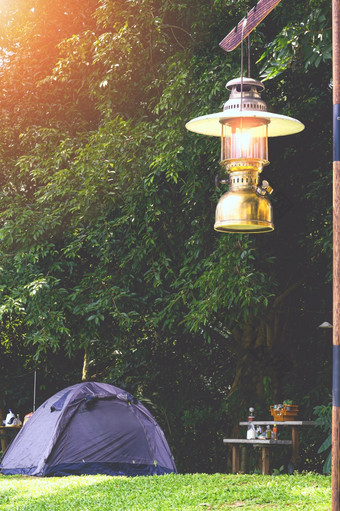 照亮古董挂黄铜野营灯笼与场帐篷绿色草坪上野营区域自然公园晚上时间