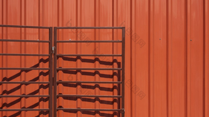 开放棕色（的）折叠金属车库门橙色波纹钢墙背景