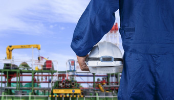 关闭工程师手蓝色的机械师连身裤持有白色安全头盔之前工作原油石油油轮船厂区域