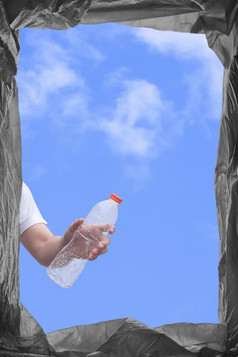 视图从下面年轻的男人。手扔塑料水瓶成垃圾本垂直框架