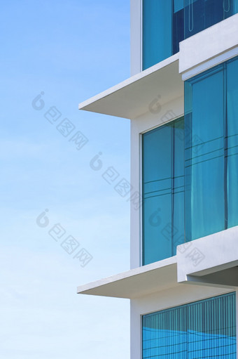 一边视图蓝色的辊百叶窗内部玻璃墙现代办公室建筑对蓝色的天空垂直框架