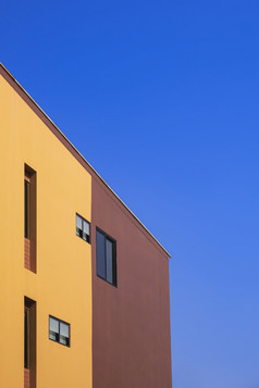 一边视图各种各样的修复玻璃窗户橙色和棕色（的）墙现代房子对蓝色的清晰的天空最小的风格和垂直框架