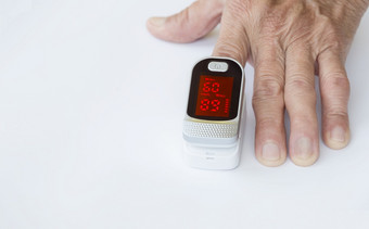 焦点脉冲血氧计指数手指上了年纪的手白色表格前测量血氧气和脉冲