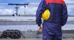 后视图工程师蓝色的机械师连身裤持有黄色的安全头盔之前工作石油油轮船厂区域
