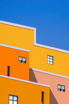 操纵技术为建筑功能背景设计色彩斑斓的建筑对蓝色的清晰的天空低角视图和垂直框架