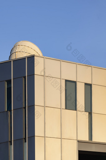 阳光反射表面现代建筑墙与通风烟囱对蓝色的清晰的天空的角度来看一边视图和垂直框架