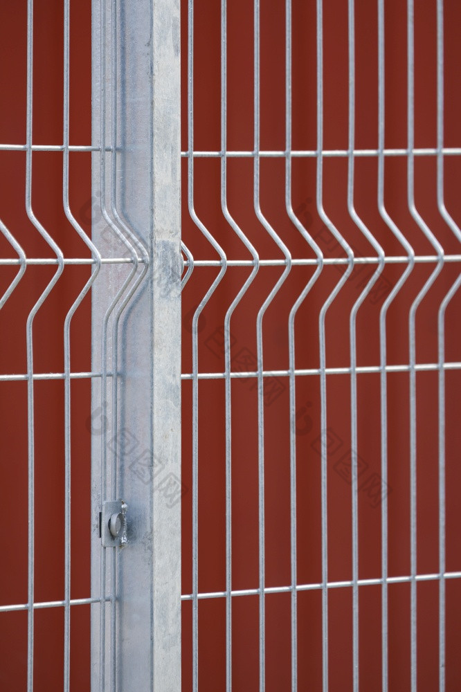 焦点预制栅栏帖子和光栅线面板与模糊红色的钢墙背景垂直框架