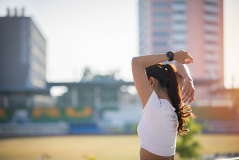 运动女人亚洲气候变暖和年轻的女运动员坐着锻炼和伸展运动城市之前跑步者在户外健康的生活方式概念