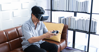 高级亚洲男人。使用平板电脑和虚拟现实模拟器玩游戏生活房间和感觉快乐生活方式高级家庭首页概念