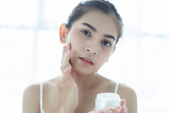 美丽的女人亚洲使用皮肤哪产品保湿霜乳液采取哪她的干肤色保湿奶油女手