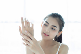 美丽的女人亚洲使用皮肤哪产品保湿霜乳液采取哪她的干肤色保湿奶油女手