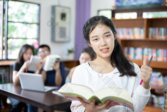 亚洲女学生持有为选择书图书馆