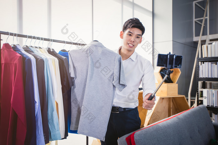 亚洲男人。博主广播视频为销售产品在线这样的帽子鞋子耳机服装安全头购物在线概念首页