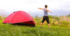 男人。锻炼和运动员气候变暖早....附近帐篷野营旅行的山