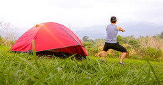 男人。锻炼和运动员气候变暖早....附近帐篷野营旅行的山