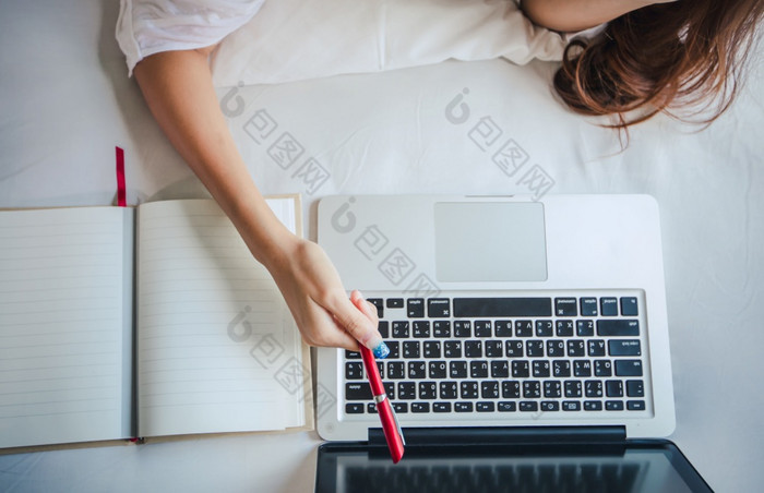 亚洲女人使用笔记本电脑为工作首页和她坐着她的床上和她检疫在的冠状病毒疫情
