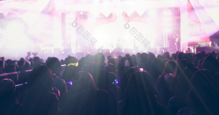 模糊的轮廓音乐会人群后视图节日人群提高他们的手明亮的阶段灯