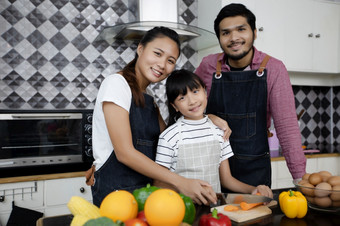 快乐家庭有<strong>爸爸</strong>妈妈和他们的小女儿烹饪在一起的<strong>厨房</strong>