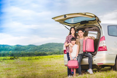 快乐小女孩与亚洲家庭坐着的车为享受路旅行和夏天假期露营者的
