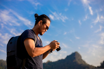 亚洲男人。旅游使用相机为采取<strong>图片风景</strong>和山放松时间假期概念旅行