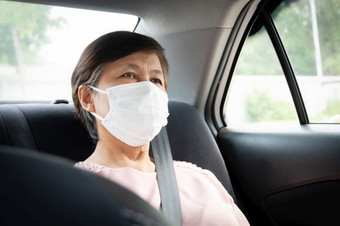 亚洲高级女人乘客穿保护外科手术面具为防止冠状病毒新冠病毒而坐着车保护为细菌和病毒流感大流行公共运输环境卫生健康的和健康哪概念