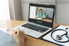 亚洲医生和医生团队使视频会议为报告讨论咨询为流感大流行病毒在一起通过互联网和无线技术与移动PC电脑会议医疗房间后视图