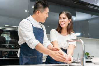 亚洲夫妇洗手与泡沫<strong>肥</strong>皂之前烹饪在一起<strong>快乐</strong>微笑年轻的男人。和女人清洁和摩擦指甲和手指与<strong>水水</strong>槽厨房卫生防止冠状病毒