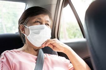 亚洲上了年纪的女人乘客穿保护外科手术面具为防止冠状病毒新冠病毒而坐着车保护为细菌和病毒流感大流行公共运输环境卫生健康的和健康哪概念
