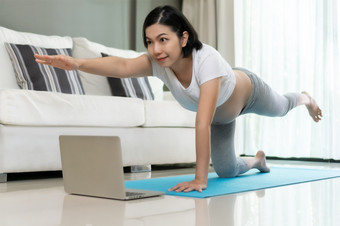健身美丽的亚洲怀孕了女人练习瑜伽与在线类移动PC<strong>首页健康</strong>的年轻的女伸展运动在锻炼而她的怀孕锻炼<strong>健康</strong>和<strong>健康</strong>哪