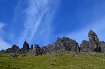 岩石形成的岛斯凯岛与绿色滚动山和蓝色的天空