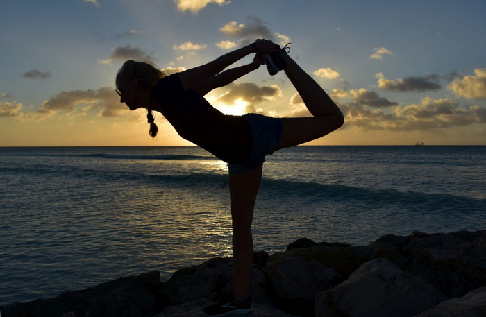 silhoutted舞者平衡构成对的太阳设置阿鲁巴岛