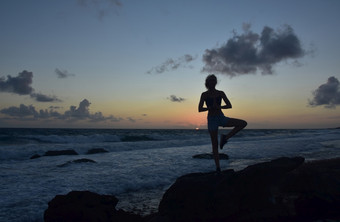 的轮廓瑜伽树构成日出的海岸阿鲁巴岛