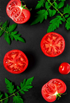半成熟的红色的西红柿叶子和分支机构西红柿黑色的石头背景成熟的蔬菜成分为的准备沙拉菜