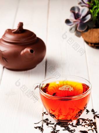 玻璃杯与红色的<strong>茶茶</strong>仪式新鲜酿造黑色的<strong>茶茶叶子</strong>的表格温暖的软光白色木背景特写镜头