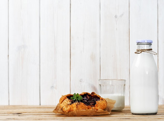 galette与李子玻璃与牛奶和瓶与牛奶特写镜头早餐午餐概念白色木背景