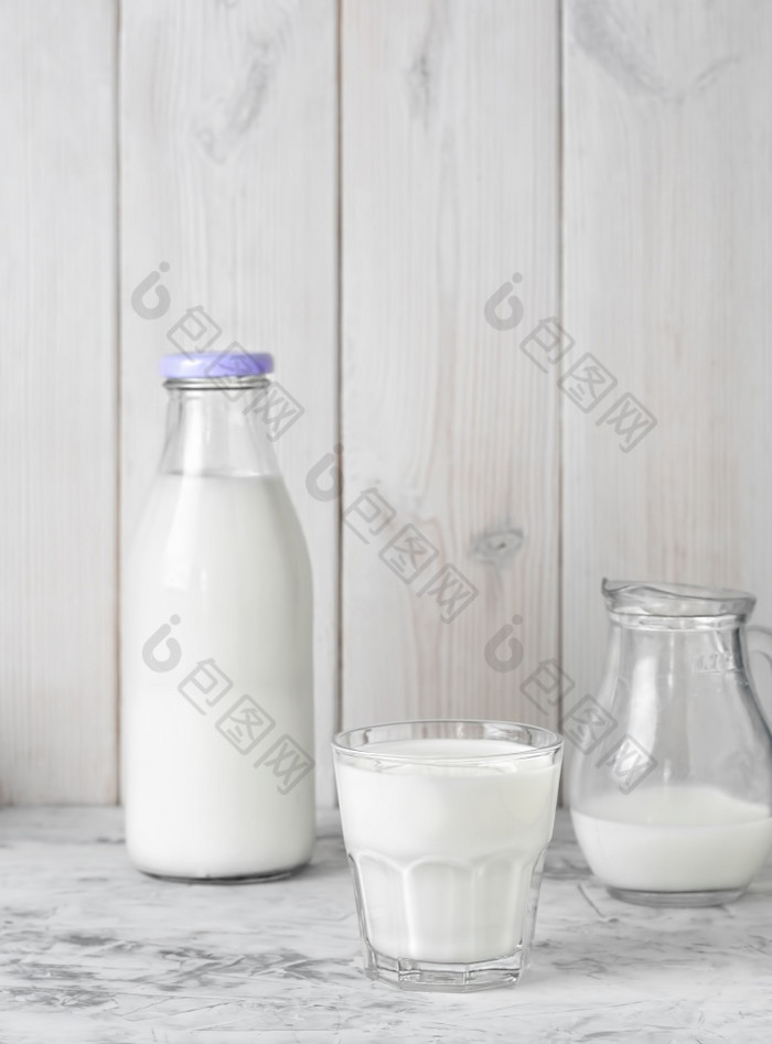 杯子与牛奶瓶牛奶和壶牛奶灰色的表格白色木背景与复制空间早餐概念健康的食物可重用的玻璃器皿杯子与牛奶瓶牛奶和壶牛奶灰色的表格