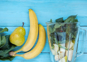 健康的食物冰沙和成分为排毒香蕉梨菠菜叶子蓝色的木背景前视图复制空间