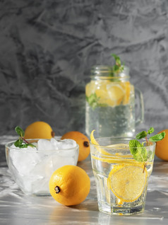 一个玻璃与柠檬水莫吉托鸡尾酒与柠檬和薄荷和杯与冰冷让人耳目一新喝饮料与冰黑暗背景复制空间