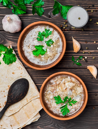 卡什碗传统的汤菜的中间东肉肉汤服务与蔬菜大蒜和的国家面包亚美尼亚式面包粘土盘子木背景与复制空间