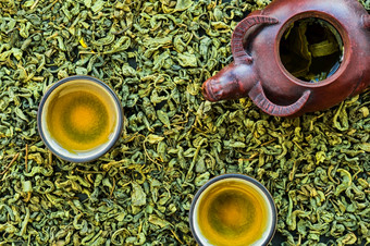 热绿色茶杯陶瓷茶壶石头表格布局发酵茶叶子是分散的表格视图从以上最小的