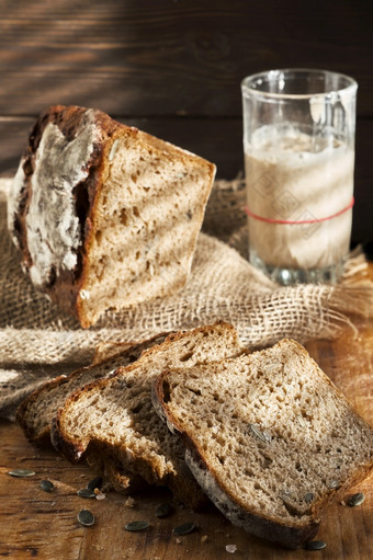 发酵面包整个粮食黑麦面包与南瓜和向日葵种子酵起动器表格真实的酵母面包有机生物产品健康的食物概念传统的工艺面包特写镜头