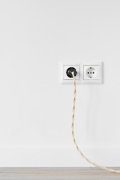 新白色塑料欧洲电出口孤立的白色贴墙电插头与古董电缆插成出口灰色的木地板上复制空间